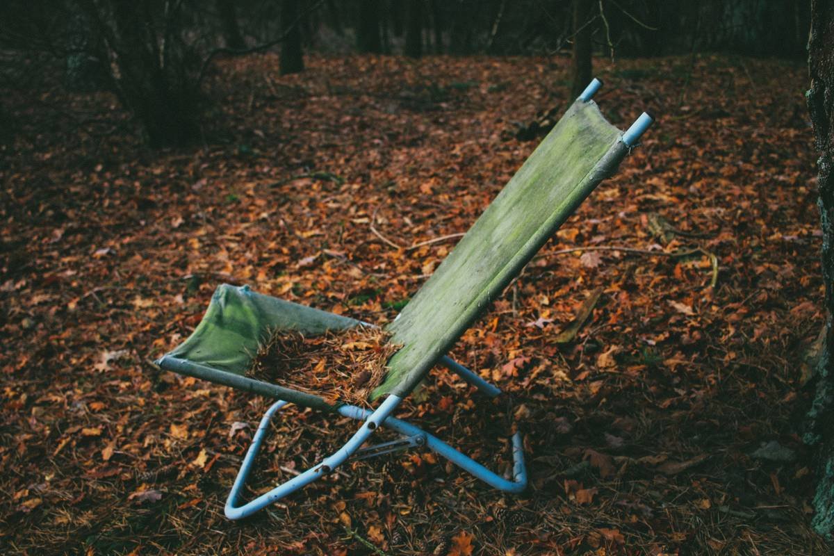 A serene image of someone enjoying the view while sitting on a foldable trail stool.